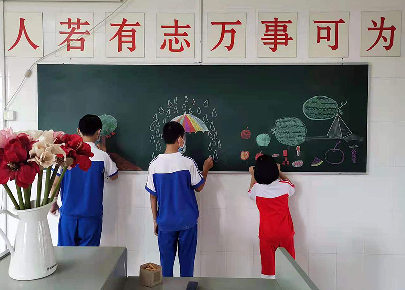 受助儿童在黑板上自由绘画.jpg